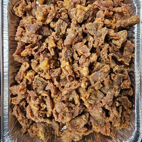 Crispy fried beef pieces, a Chinese dish from Mr Nosh, served in a foil tray.