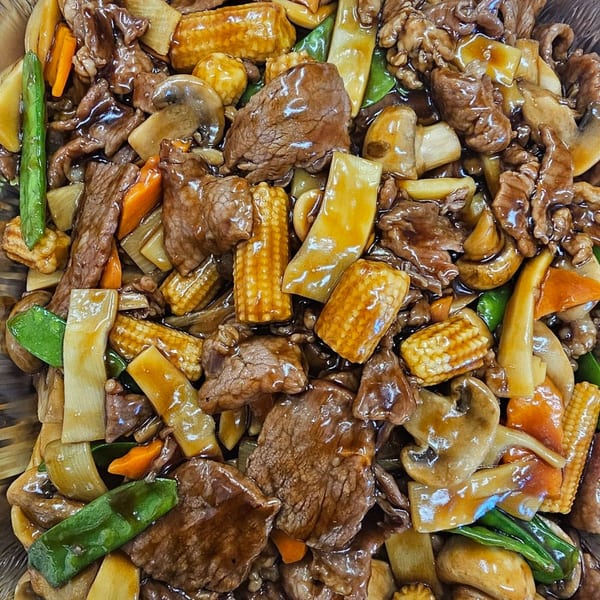 Mr Nosh's Chinese beef stir-fry with baby corn, mushrooms, carrots, and snow peas in a rich sauce.
