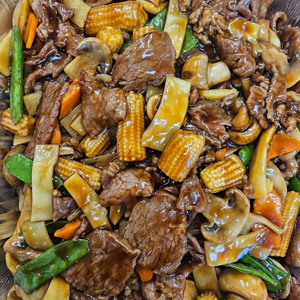 Mr Nosh's Chinese beef stir-fry with baby corn, mushrooms, carrots, and snow peas in a rich sauce.