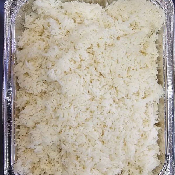 Fluffy white rice fills a rectangular aluminum foil container, ready for a Chinese meal.